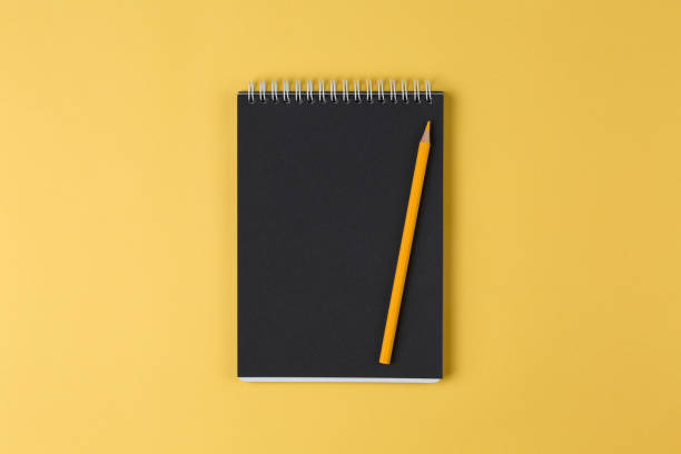 notebook with black paper and pencil on a yellow background top view - 4605 imagens e fotografias de stock