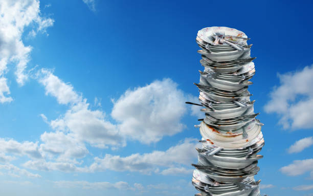close up pile of dirty dishes over cloudy blue sky