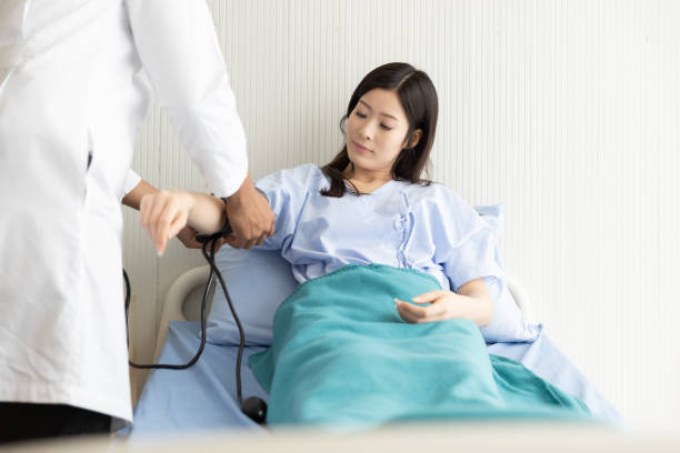 médico que revisa la presión arterial de las mujeres asiáticas pacientes acostadas en una cama de hospital - human heart physical pressure arterial doctor fotografías e imágenes de stock