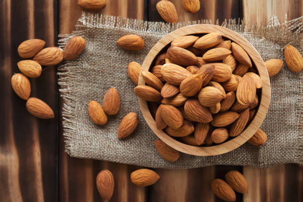 istock almonds in bowl wood on dark table background 1173053308