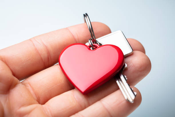 istock Human Hand Holding Red Heart Shape Key Chain With Key 1173054940