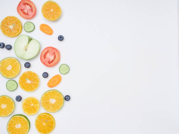 Fresh fruits and vegetables sliced placed on white background. carrot, orange, blueberry, apple, lemon, tomato, cucumber