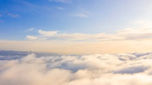 Photo of Aerial view White clouds in blue sky. Top view. View from drone. Aerial bird's eye view. Aerial top view cloudscape. Texture of clouds. View from above. Sunrise or sunset over clouds