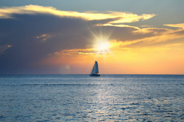 istock shiny sea and sailboat over cloudy sunset sky 1173066132