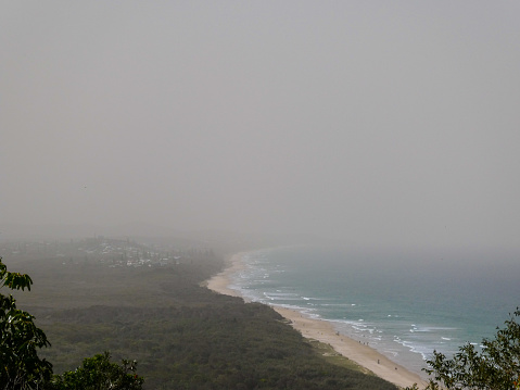 In September 2019 a thick smoke and dust haze blanketed southeast Queensland due to bushfires raging in Qld and northern NSW. Seen here is the haze over Coolum Beach on the Sunshine Coast, on a day of very high fire danger and extremely dry conditions. Asthmatics and those with respiratory conditions were advised to stay indoors with doors and windows shut and medication close by.
