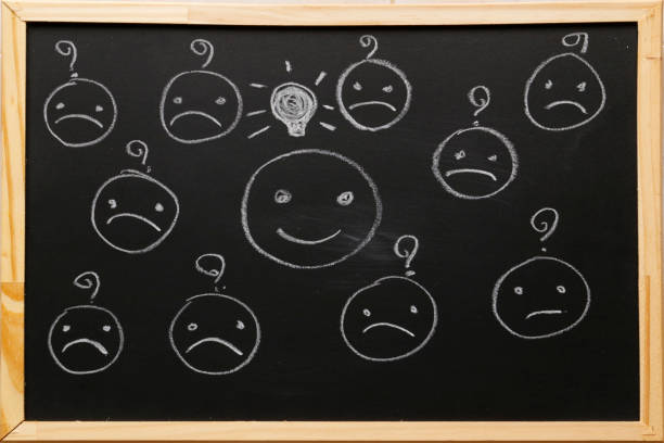 istock Write smiley face symbol with light bulb icon and blurred sad face symbol have question on blackboard with chalk. Service rating, satisfaction concept. 1173076098