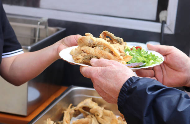 istock woman handing fried fish to a man 1173076232