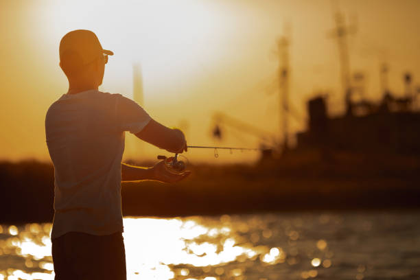 istock Young man fishing at sea 1173078077