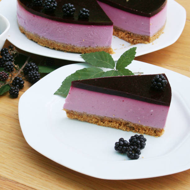 istock Blackberry cheesecake on a white plate on wooden table. 1173080153