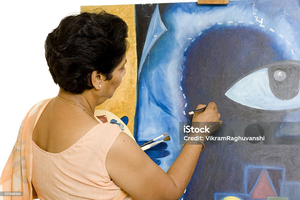 Um artista indígena mulher sênior trabalhando em seu quadro - Foto de stock de Terceira idade royalty-free