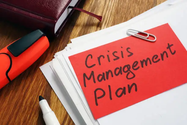 Photo of Crisis Management Plan on an office desk and papers.