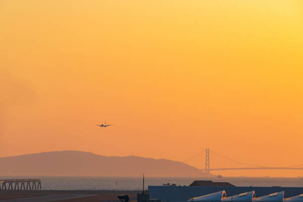 passagierflugzeug am abendhimmel - kobe bridge japan suspension bridge stock-fotos und bilder