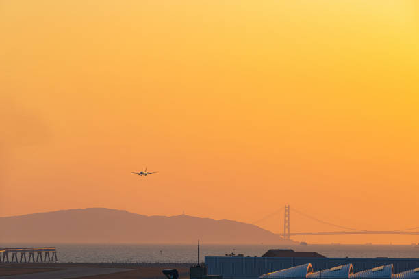 aereo passeggeri nel cielo serale - kobe bridge japan suspension bridge foto e immagini stock