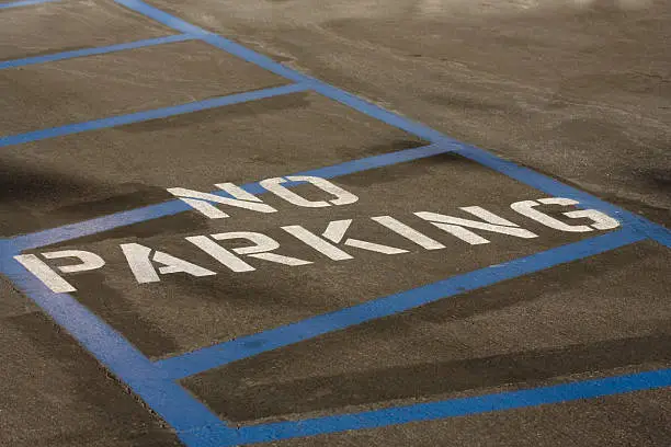 Blue strips and stencil letters mark out no parking zone.