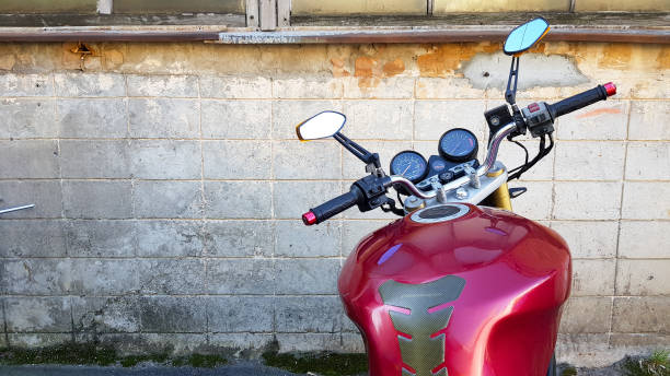 istock Red motorcycle parked in a gray brick wall. First-person view, dashboard and steering wheel 1173085195