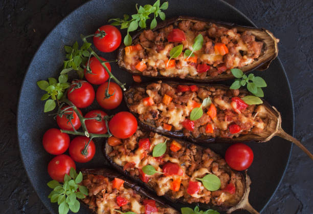 istock Stuffed with minced meat with vegetables eggplant-a delicious healthy dinner on a black plate on a black textured background. Snack. The view from the top. 1173088039