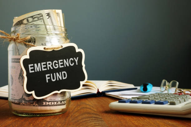 emergency fund savings written on the jar with money. - emergência imagens e fotografias de stock