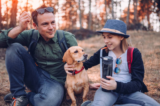 istock Family with dog resting in pine forest 1173092347