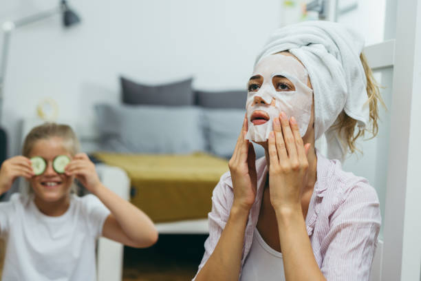istock mother and daughter having fun applying face mask at home 1173095696
