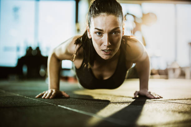istock Determined athletic woman exercising push-ups in a gym. 1173098325
