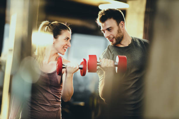 istock Happy athletic couple talking while exercising with dumbbells in a gym. 1173099703