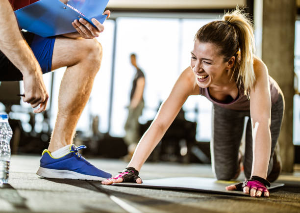 istock Cheerful female athlete having a training with her unrecognizable coach in a gym. 1173100732