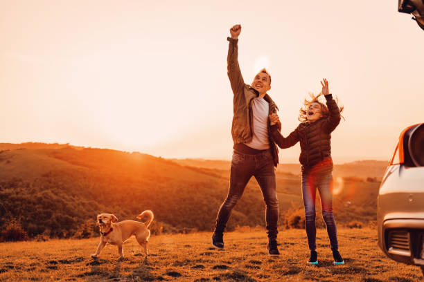 istock Father and daughter holding hands and jumping at camping on a hill 1173101063