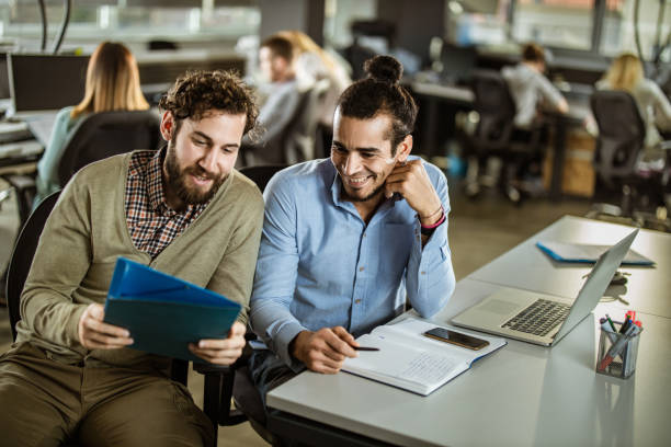 istock Young happy businessmen cooperating while reading documents in the office. 1173103211