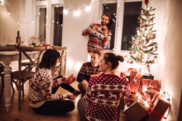 przyjaciele wymiana prezent świąteczny w domu - giving christmas lifestyles holiday zdjęcia i obrazy z banku zdjęć