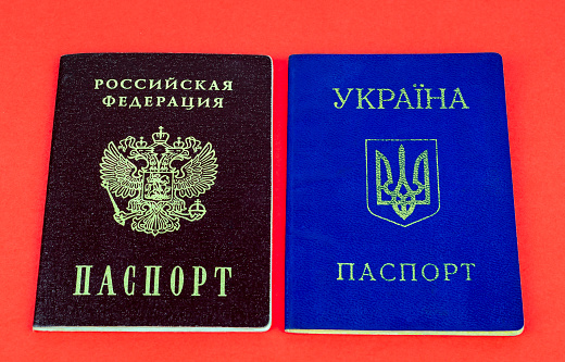 Two national internal passports, red Russian passport and blue Ukrainian passport on red background