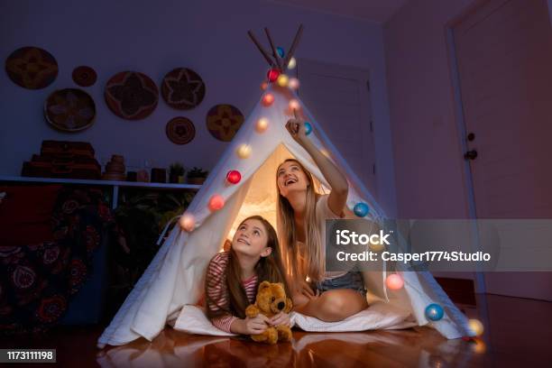 Happy Mother And Daughter Inside Tepee Tent In Bedroom Looking And Pointing Ceiling Counting Stars Family Relationship Concept Stock Photo - Download Image Now