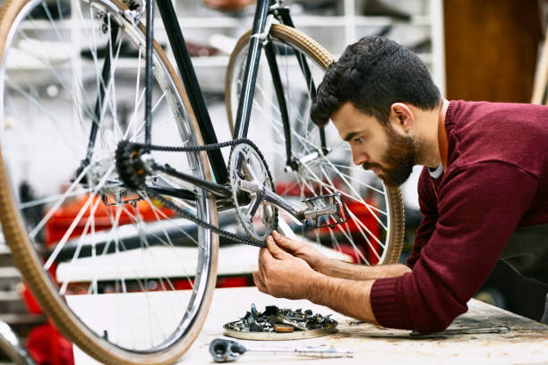 istock Confident male mechanic adjusting bicycle chain 1173111268