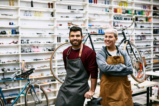 istock Smiling young coworkers leaning on workbench 1173111836
