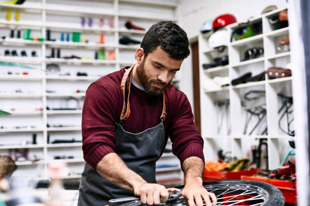 istock Confident young mechanic repairing bicycle wheel 1173111877