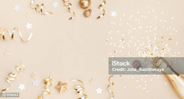Champagne Bottle With Confetti Stars Holiday Decoration And Party Streamers On Gold Festive Background Christmas Birthday Or Wedding Concept Flat Lay Stock Photo - Download Image Now