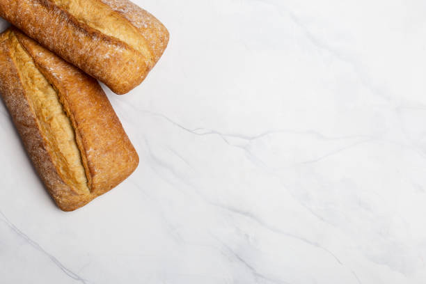 istock Loafs of bread on white marble 1173116206