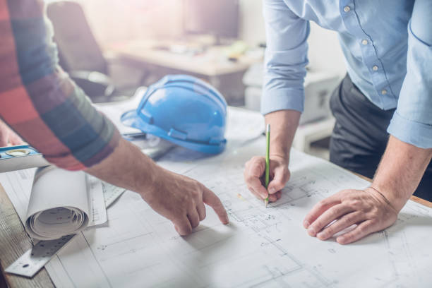 Cooperation is the key for success Hands of an architect and an engineer pointing at the architectural plan. they have a coordination meeting to make sure everything works council flat stock pictures, royalty-free photos & images