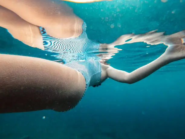 Close up photo of woman floating in the cold water with goosebumps on her skin