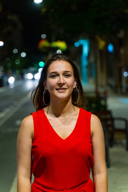 Young woman walking in a city street at night stock photo