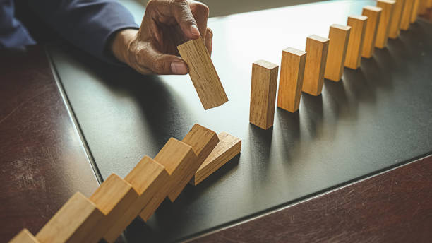 istock Problem Solving,Close up view on hand of business woman stopping falling blocks on table for concept about taking responsibility. 1173123121