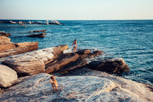 istock Girl and her dog exploring rocky beach 1173123412