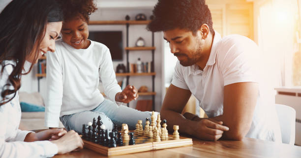 istock Happy family playing chess together at home 1173123523