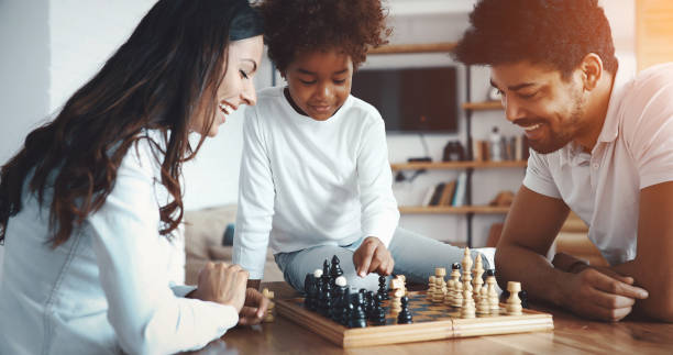 istock Happy family playing chess together at home 1173123626