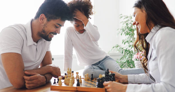 istock Happy family playing chess together at home 1173123629