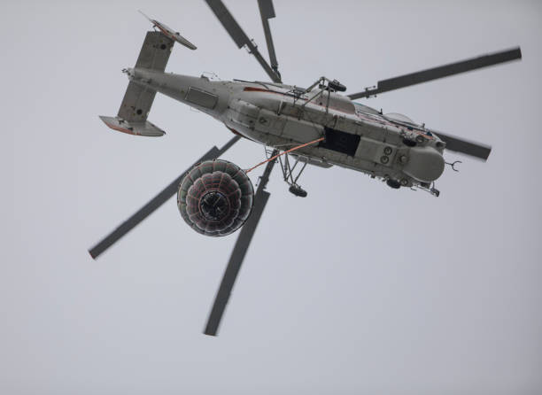 istock helicopter extinguishes a fire from a basket of water 1173125146