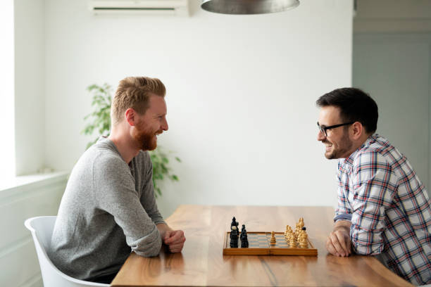 Young smart friends playing chess at home