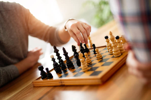 istock Young smart friends playing chess at home 1173126452
