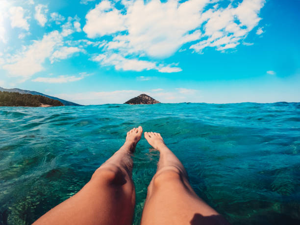 Girl floating in the sea water where are only visible legs