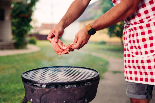 istock Men wearing apron preparing to grill chicken meat 1173128070