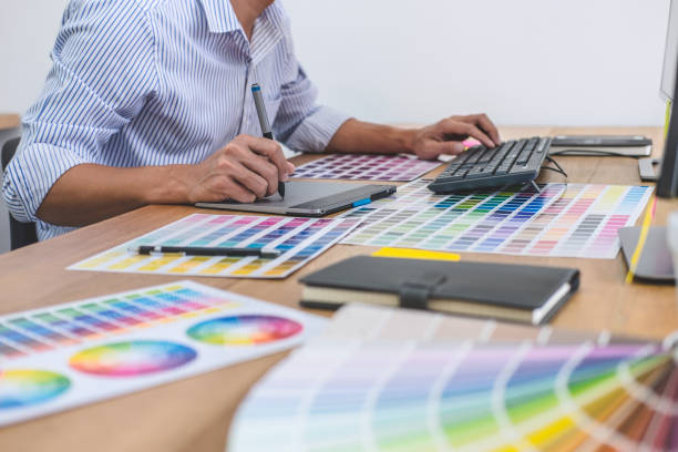 istock Image of male creative graphic designer working on color selection and drawing on graphics tablet at workplace with work tools and accessories in workspace 1173129066